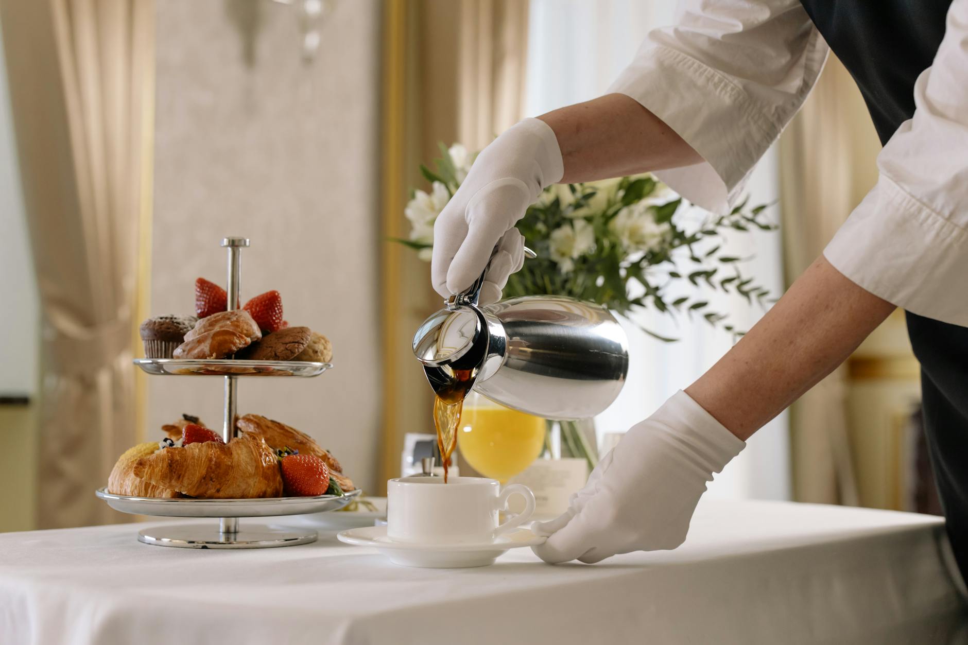 Eleganckie śniadanie: świeże pieczywo i kawa nalewana do filiżanki