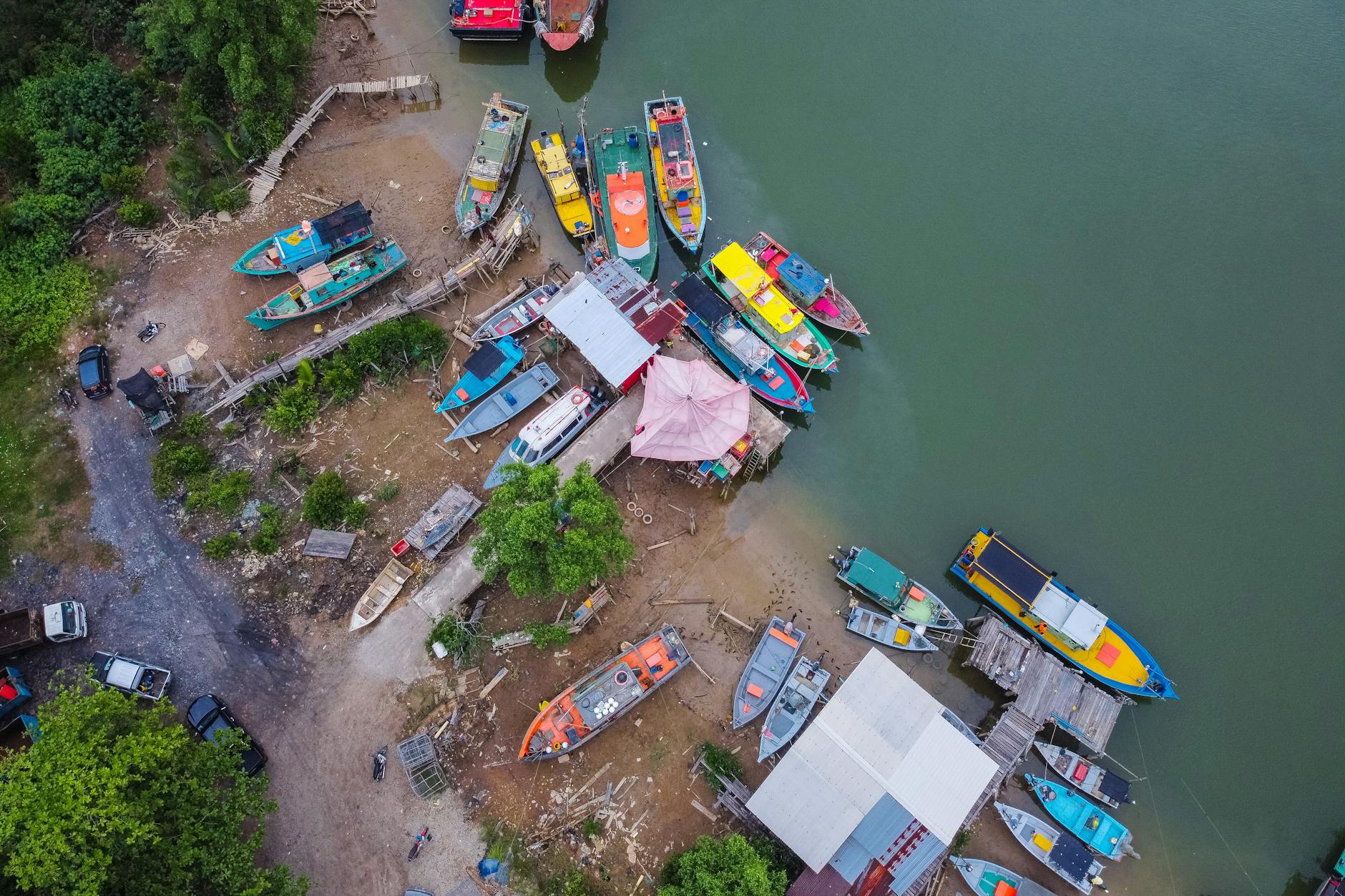 Kolorowe łodzie zacumowane nad rzeką wśród bujnej zieleni w Malezji