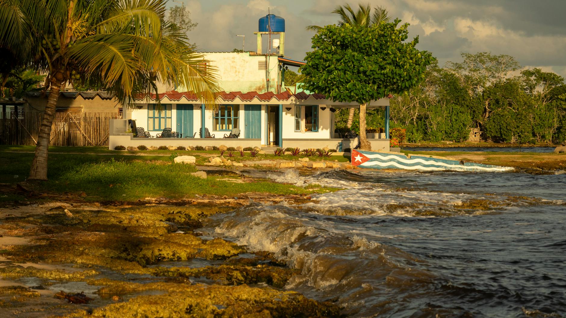 Nadmorski dom na Kubie otoczony zielenią przy falującym karaibskim morzu