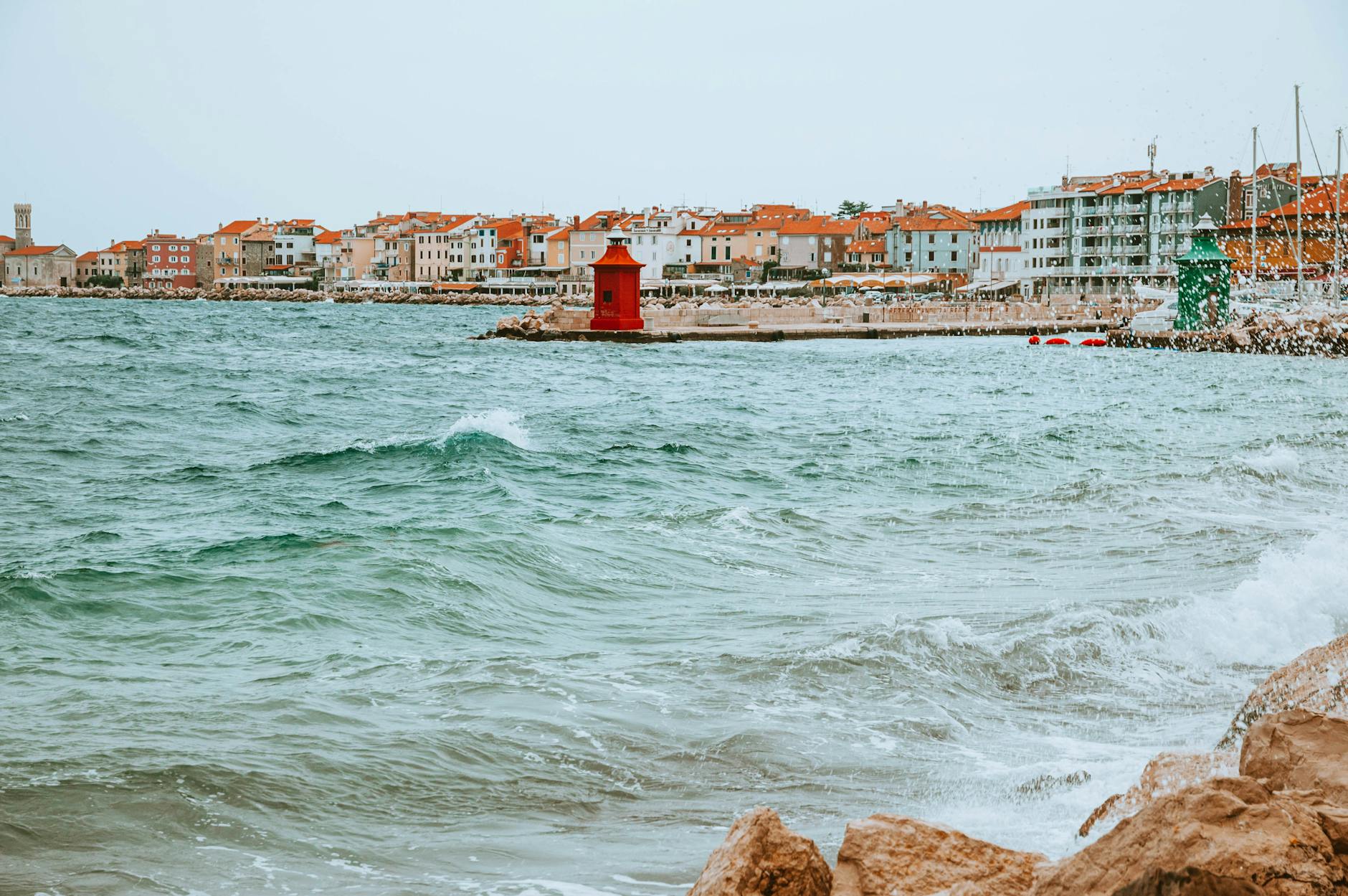 Nadmorskie miasteczko Piran w Słowenii z czerwono-białą latarnią nad Adriatykiem