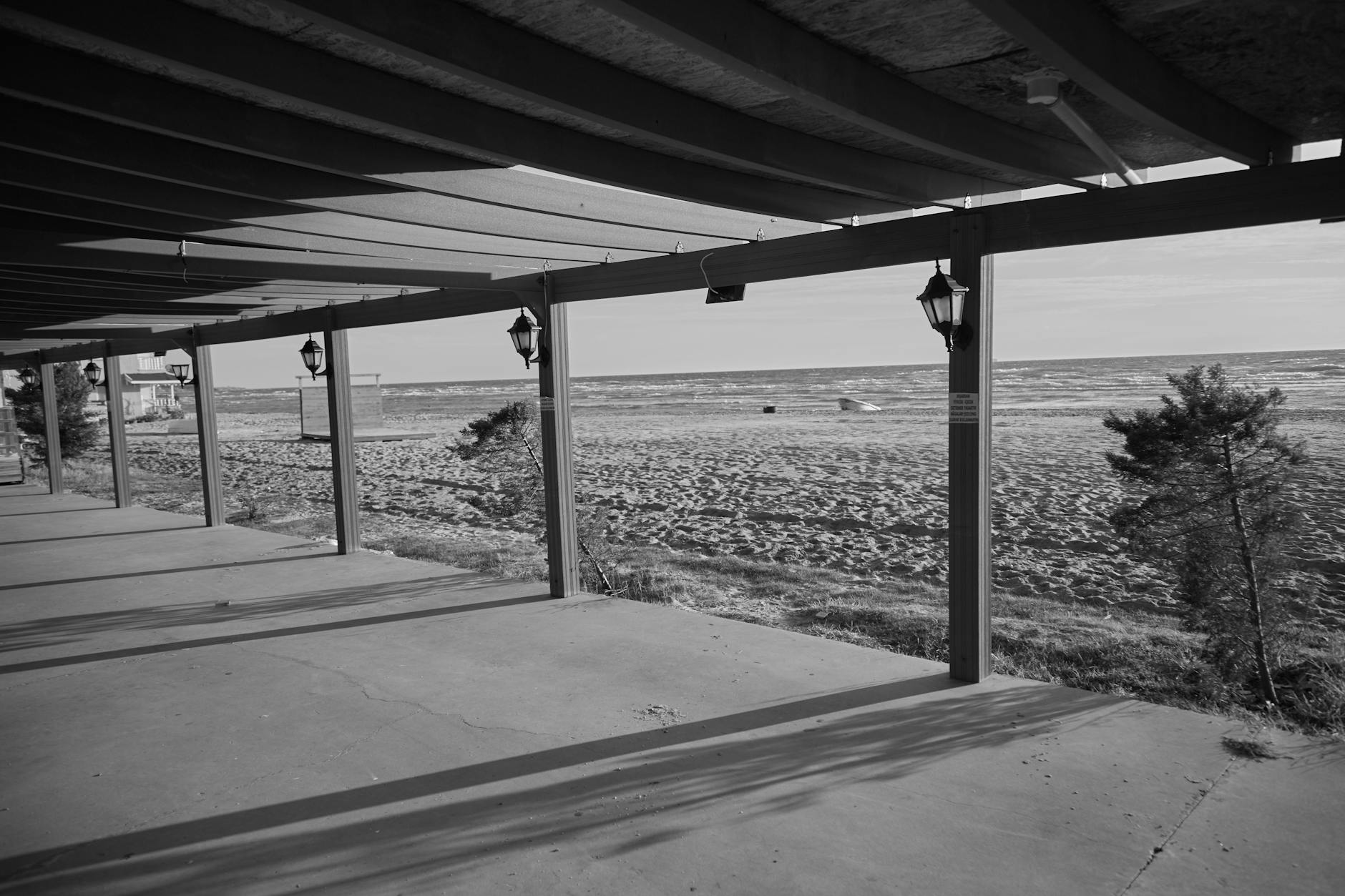 Czarno-biały deptak nad morzem z falami, spokojne pustosze plaży