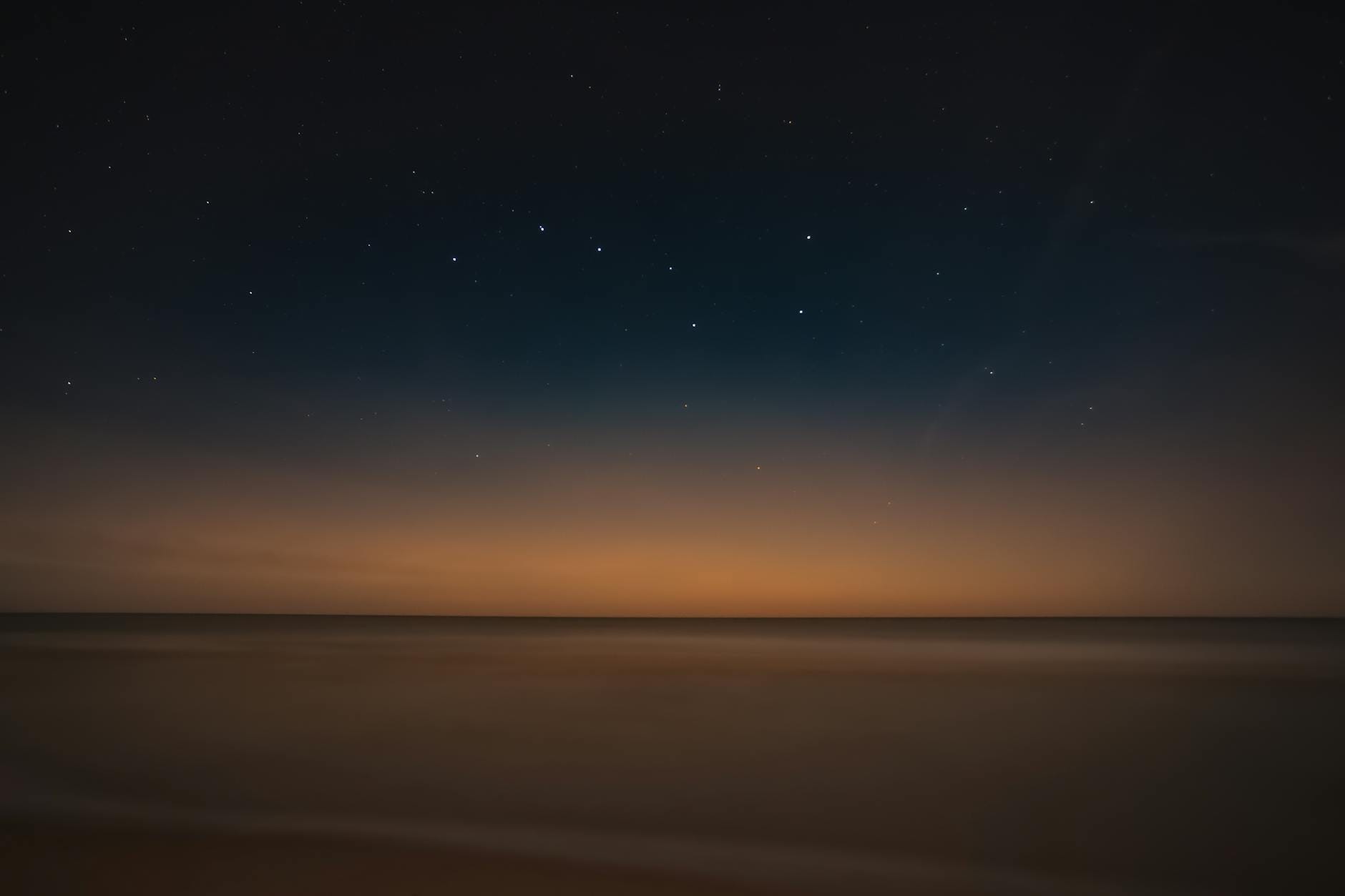 Nocny widok spokojnego morza i gwiaździstego nieba na plaży w Łebie