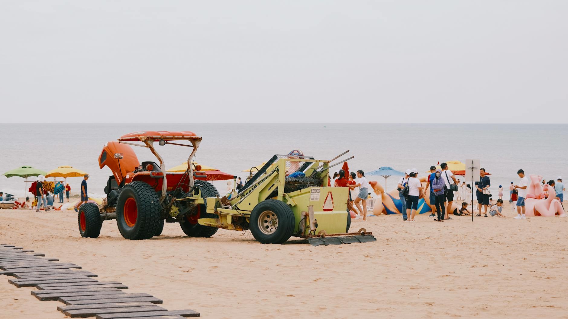 Turyści na plaży nad Bałtykiem obok traktora w słoneczny dzień