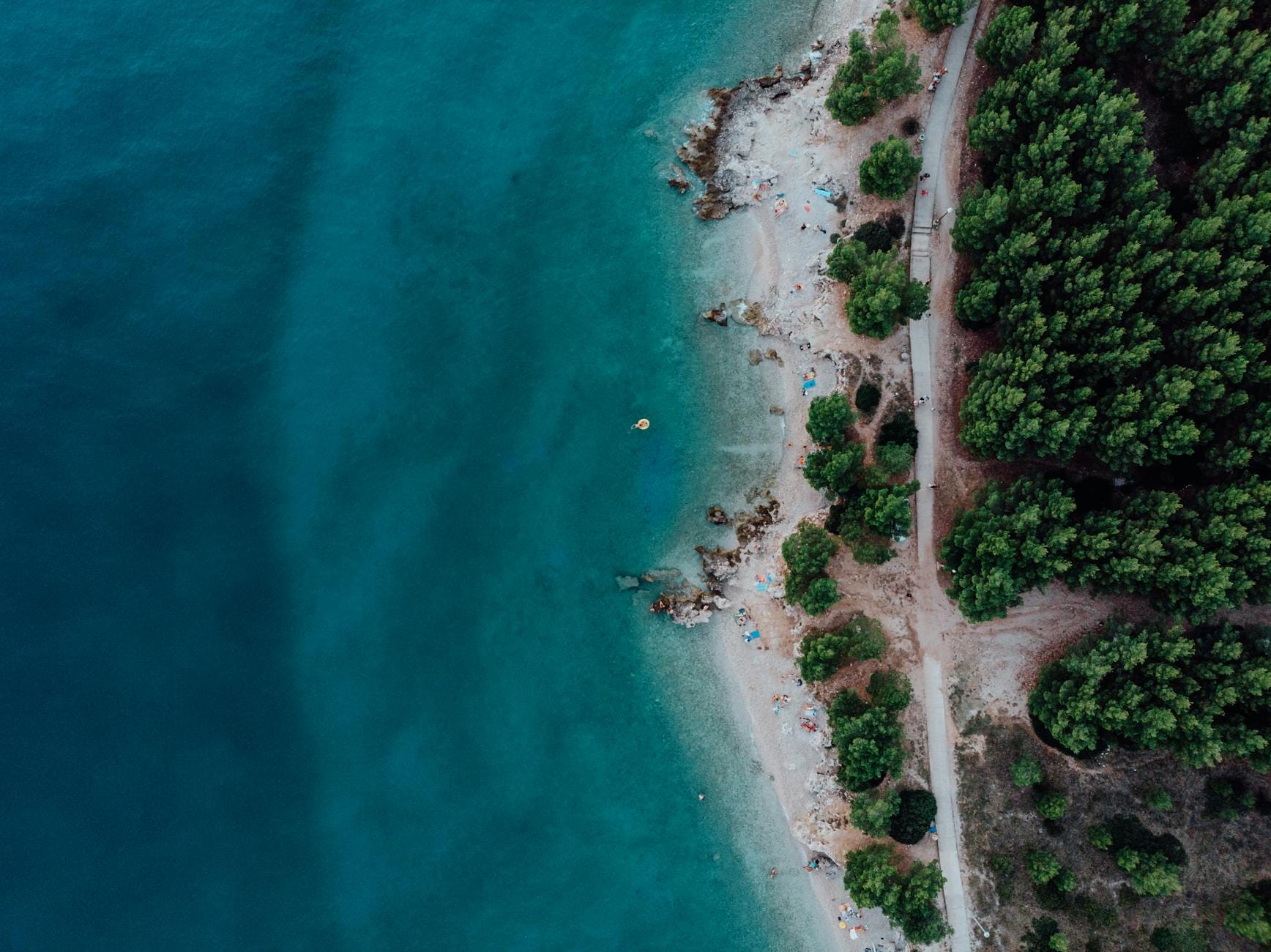 Ukryta tropikalna plaża z turkusową wodą i gęstą zielenią z lotu ptaka