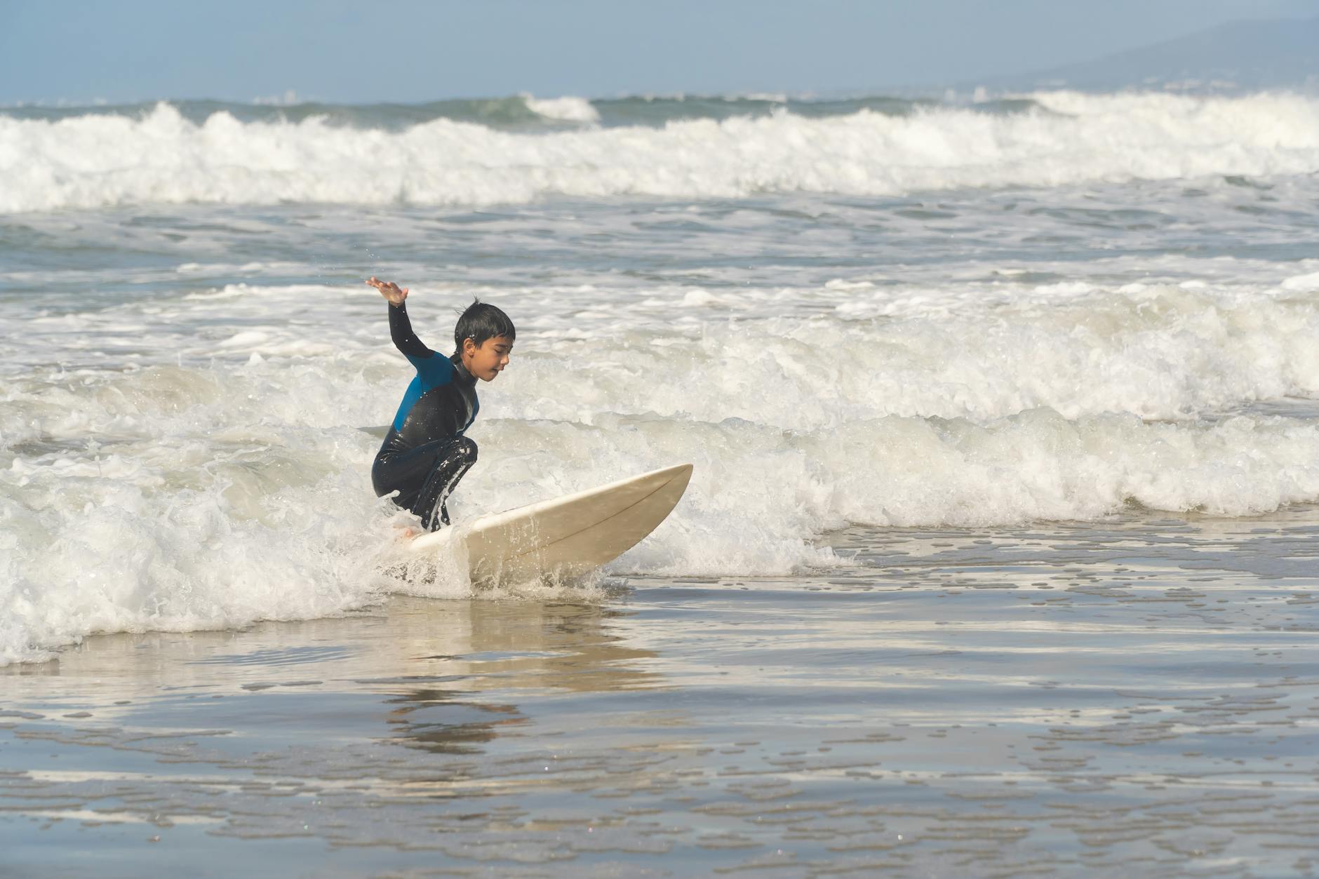 Młody surfer łapie falę na portugalskiej plaży